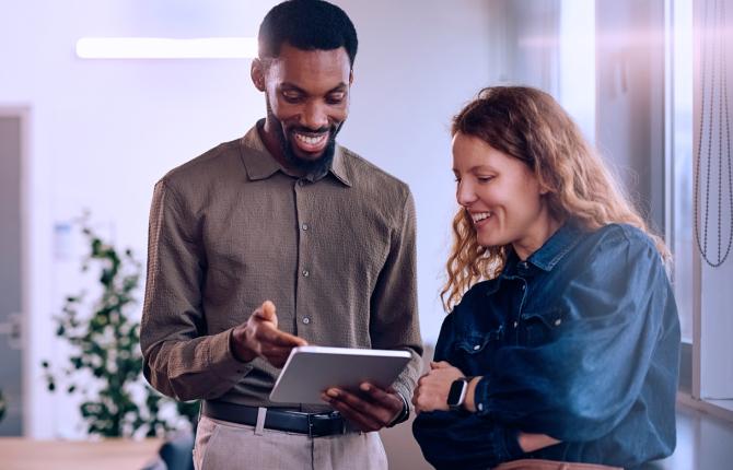 two employees reviewing a file on an ipad