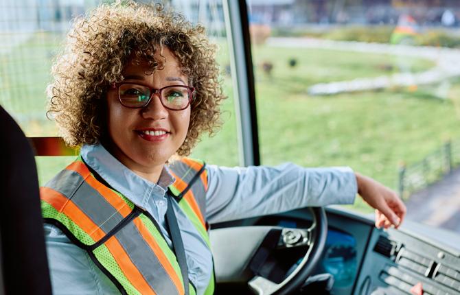 Female bus driver smiling at camera