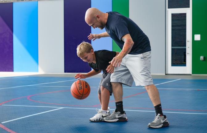 Father and son play basketball together at the YMCA