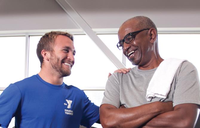 YMCA personal trainer laughing with a member after a workout.